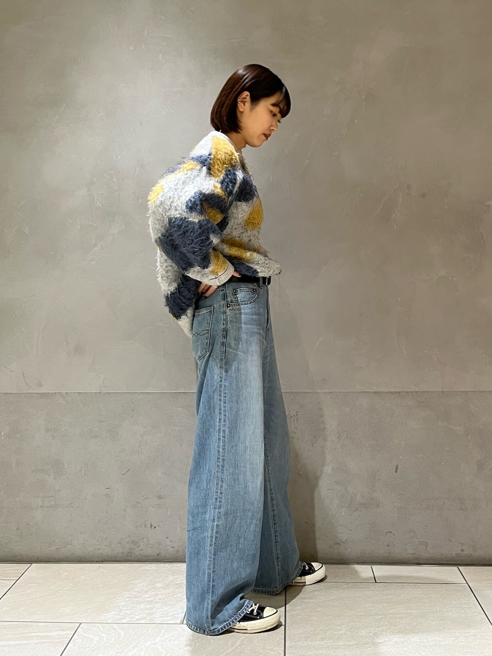 ブルー系のニット/セーター、ブルー系のデニムパンツを着用したレディースの秋コーディネートの3枚目の写真