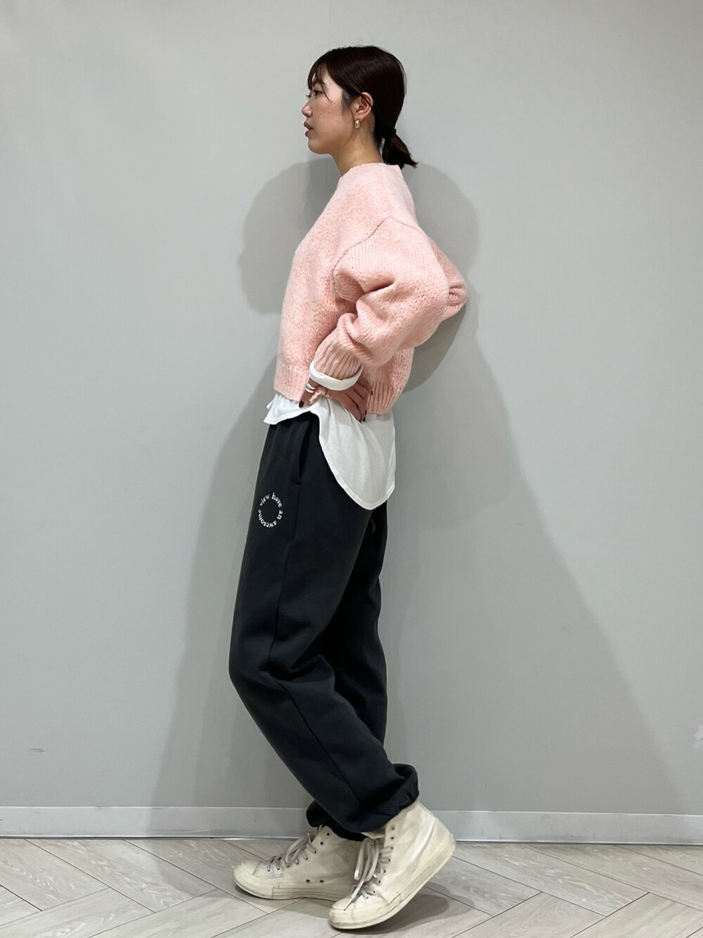 グレー系のスウェットパンツ、ピンク系のニット/セーター、ホワイト系のTシャツ/カットソーを着用したレディースの秋コーディネートの3枚目の写真