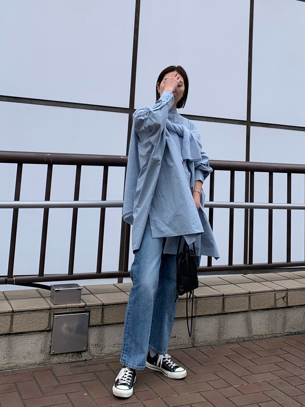 ブルー系のシャツ/ブラウス、ブルー系のニット/セーター、ブルー系のデニムパンツを着用したレディースの春コーディネートの2枚目の写真