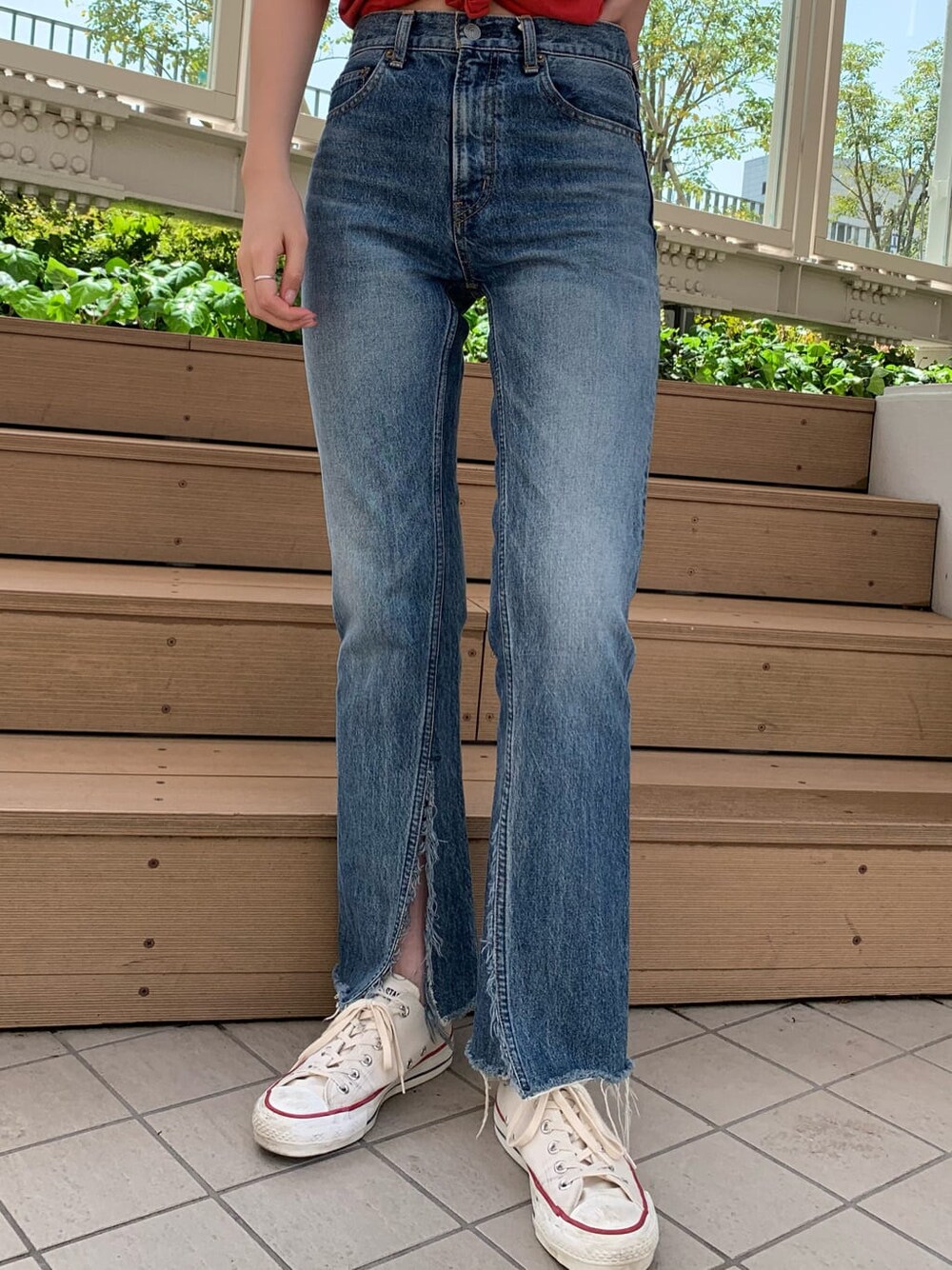 ブルー系のデニムパンツ、オレンジ系のTシャツ/カットソーを着用したレディースの春コーディネートの5枚目の写真