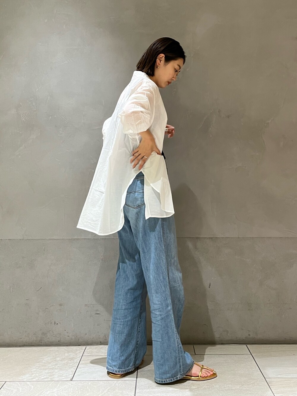 ホワイト系のシャツ/ブラウス、ブルー系のデニムパンツ、ゴールド系のサンダルを着用したレディースの夏コーディネートの4枚目の写真