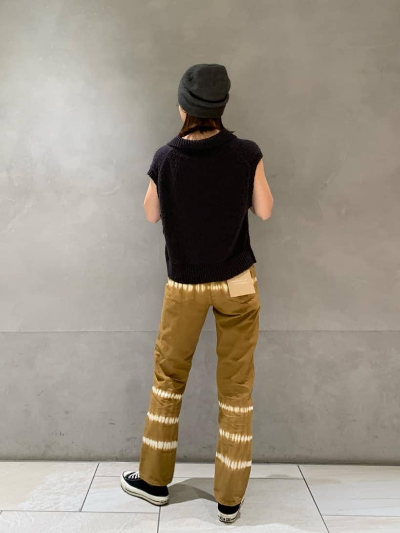 ブラウン系のデニムパンツ、グレー系のベストを着用したレディースの春コーディネートの2枚目の写真