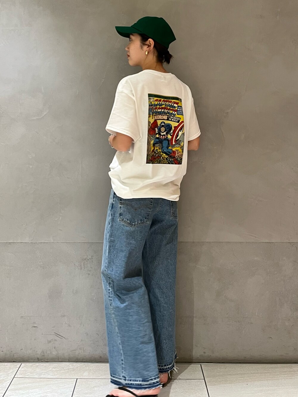 ホワイト系のTシャツ/カットソー、ブルー系のデニムパンツ、グリーン系のキャップを着用したレディースの夏コーディネートの3枚目の写真