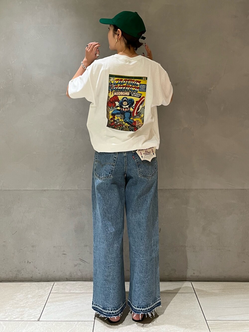 ホワイト系のTシャツ/カットソー、ブルー系のデニムパンツ、グリーン系のキャップを着用したレディースの夏コーディネートの4枚目の写真