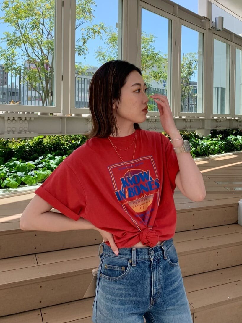 ブルー系のデニムパンツ、オレンジ系のTシャツ/カットソーを着用したレディースの春コーディネートの3枚目の写真