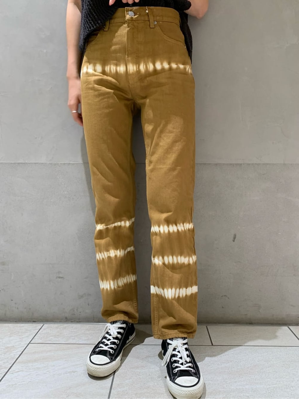 ブラウン系のデニムパンツ、グレー系のベストを着用したレディースの春コーディネートの3枚目の写真