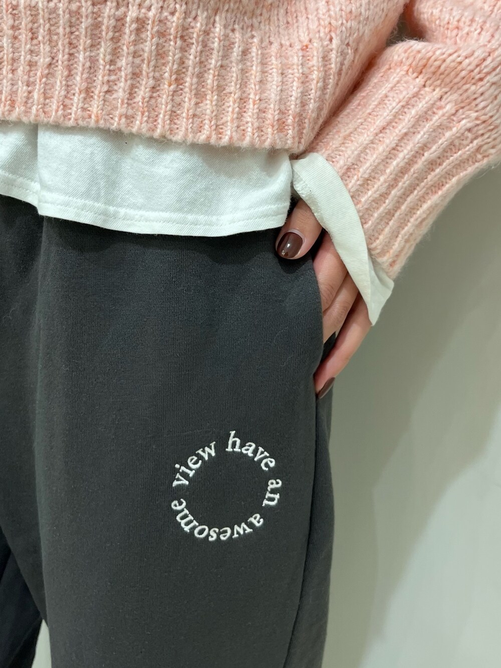 グレー系のスウェットパンツ、ピンク系のニット/セーター、ホワイト系のTシャツ/カットソーを着用したレディースの秋コーディネートの5枚目の写真