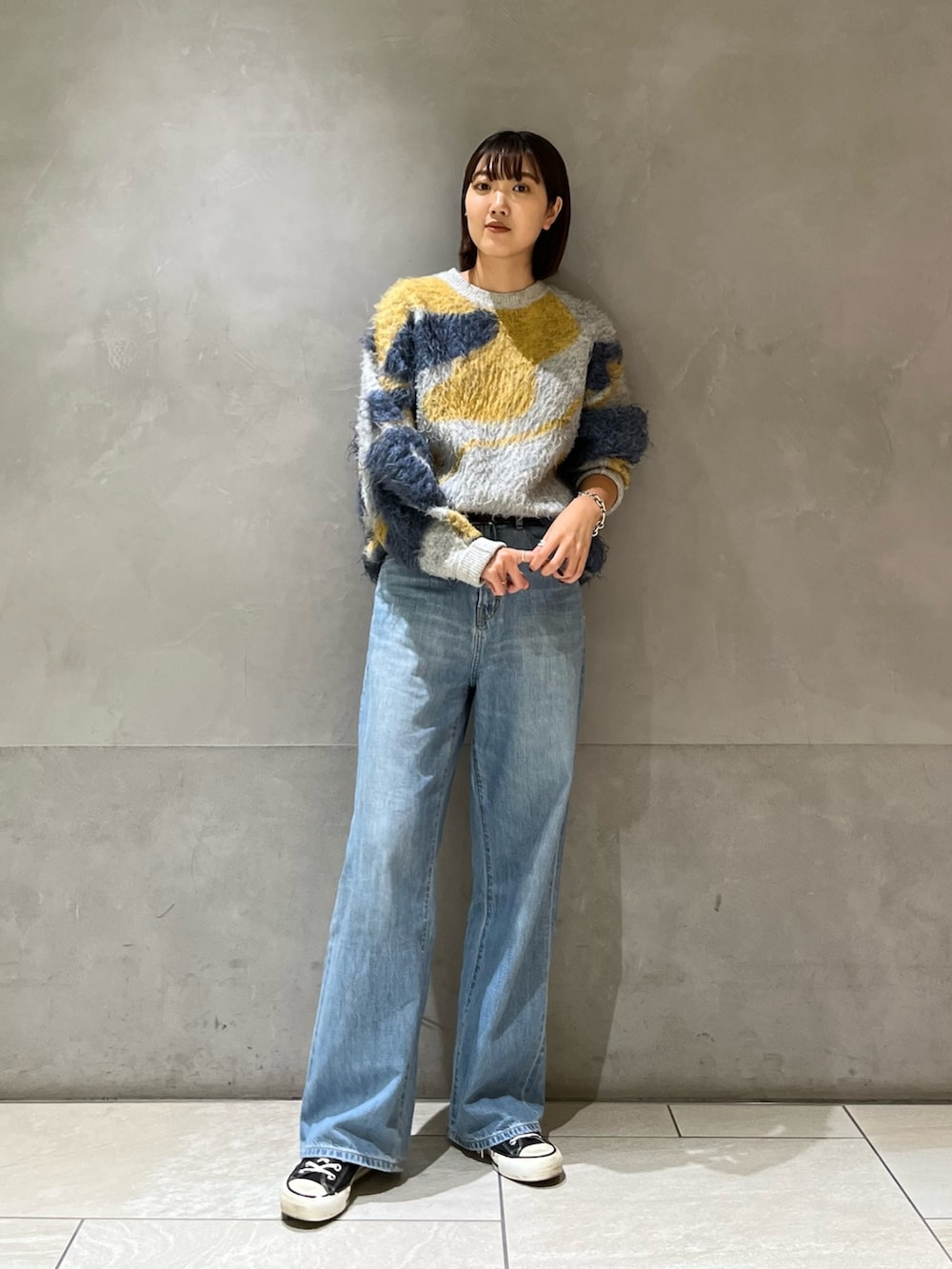 ブルー系のニット/セーター、ブルー系のデニムパンツを着用したレディースの秋コーディネートの2枚目の写真