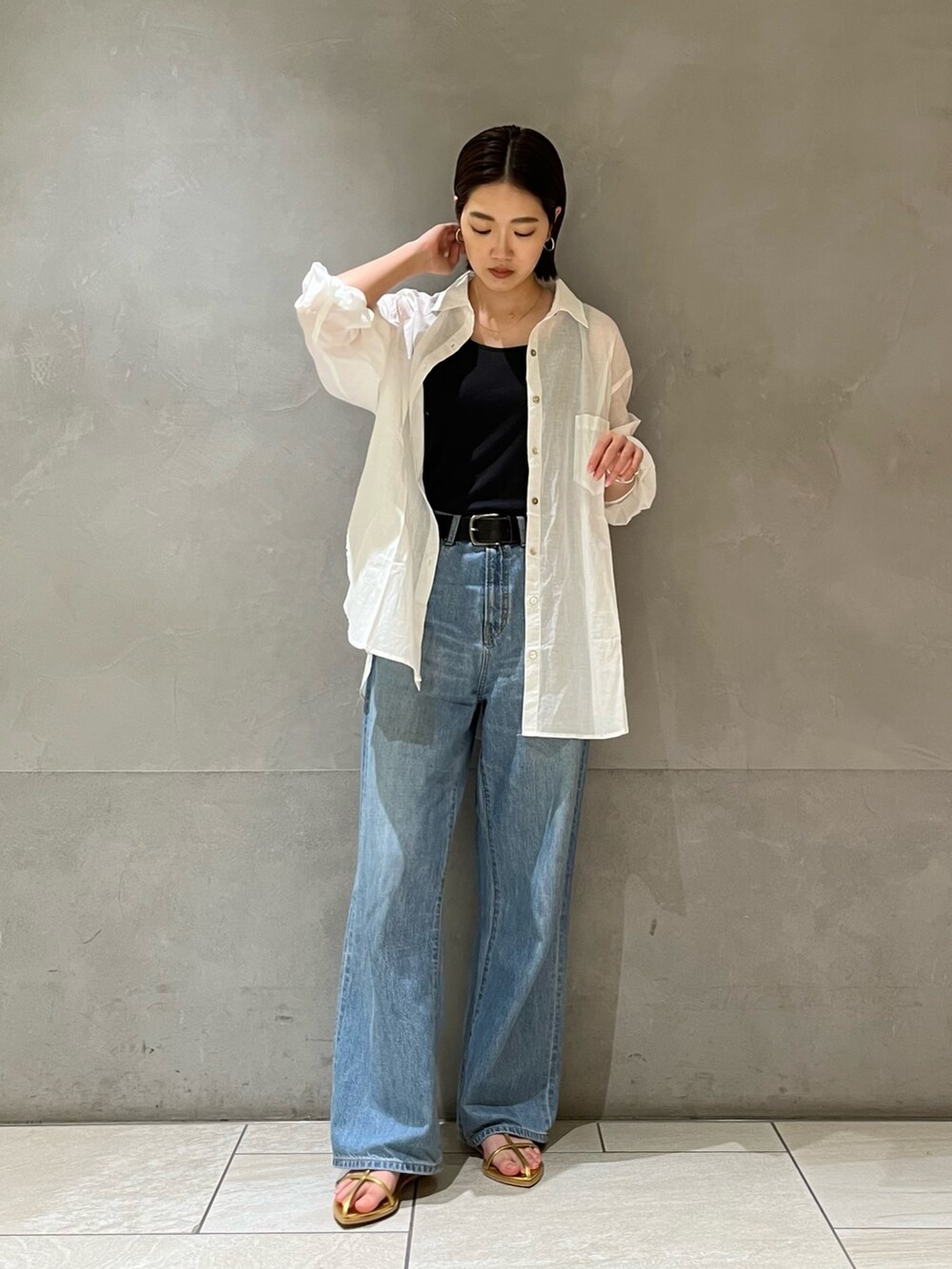 ホワイト系のシャツ/ブラウス、ブルー系のデニムパンツ、ゴールド系のサンダルを着用したレディースの夏コーディネートの3枚目の写真