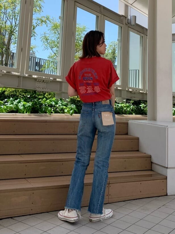 ブルー系のデニムパンツ、オレンジ系のTシャツ/カットソーを着用したレディースの春コーディネートの2枚目の写真