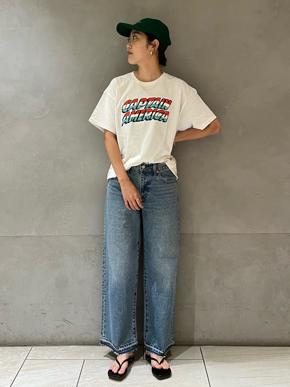 ホワイト系のTシャツ/カットソー、ブルー系のデニムパンツ、グリーン系のキャップを着用したレディースの夏コーディネートの2枚目の写真