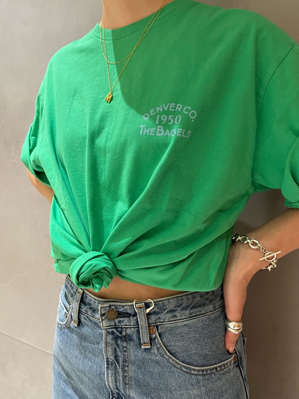 ブルー系のデニムパンツ、グリーン系のTシャツ/カットソーを着用したレディースの春コーディネートの5枚目の写真