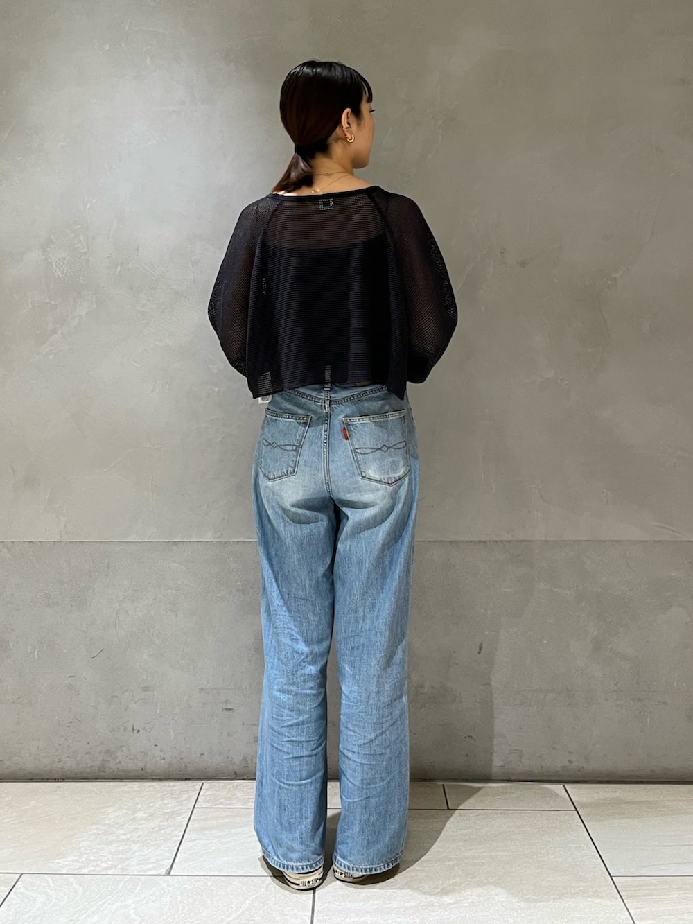 グレー系のTシャツ/カットソー、ブルー系のデニムパンツを着用したレディースの春コーディネートの3枚目の写真