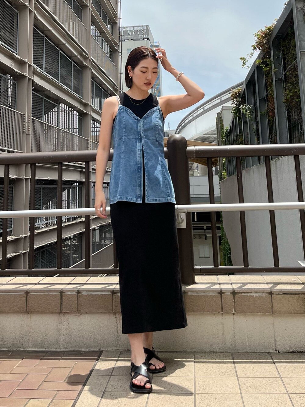 ブルー系のキャミソール、ブラック系のワンピース、ブラック系のサンダルを着用したレディースの春コーディネートの4枚目の写真