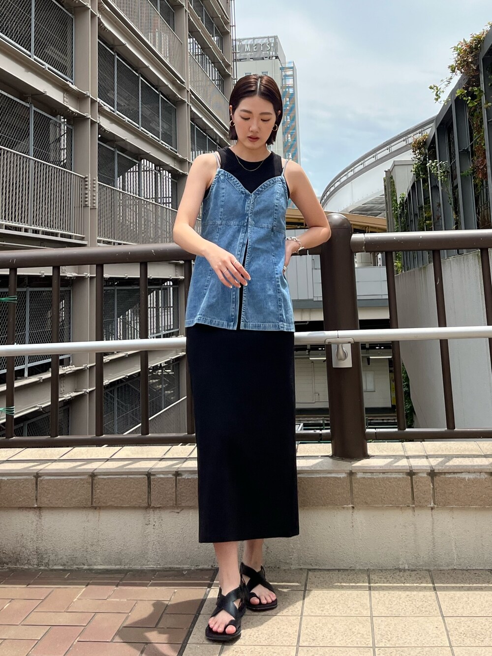 ブルー系のキャミソール、ブラック系のワンピース、ブラック系のサンダルを着用したレディースの春コーディネートの3枚目の写真
