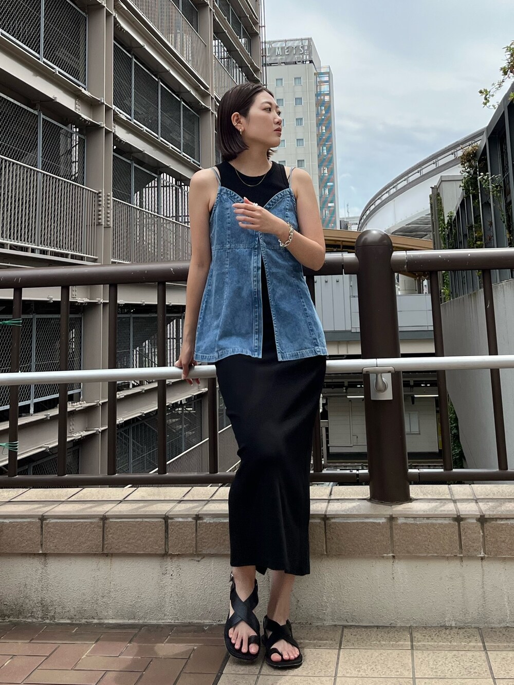 ブルー系のキャミソール、ブラック系のワンピース、ブラック系のサンダルを着用したレディースの春コーディネートの2枚目の写真