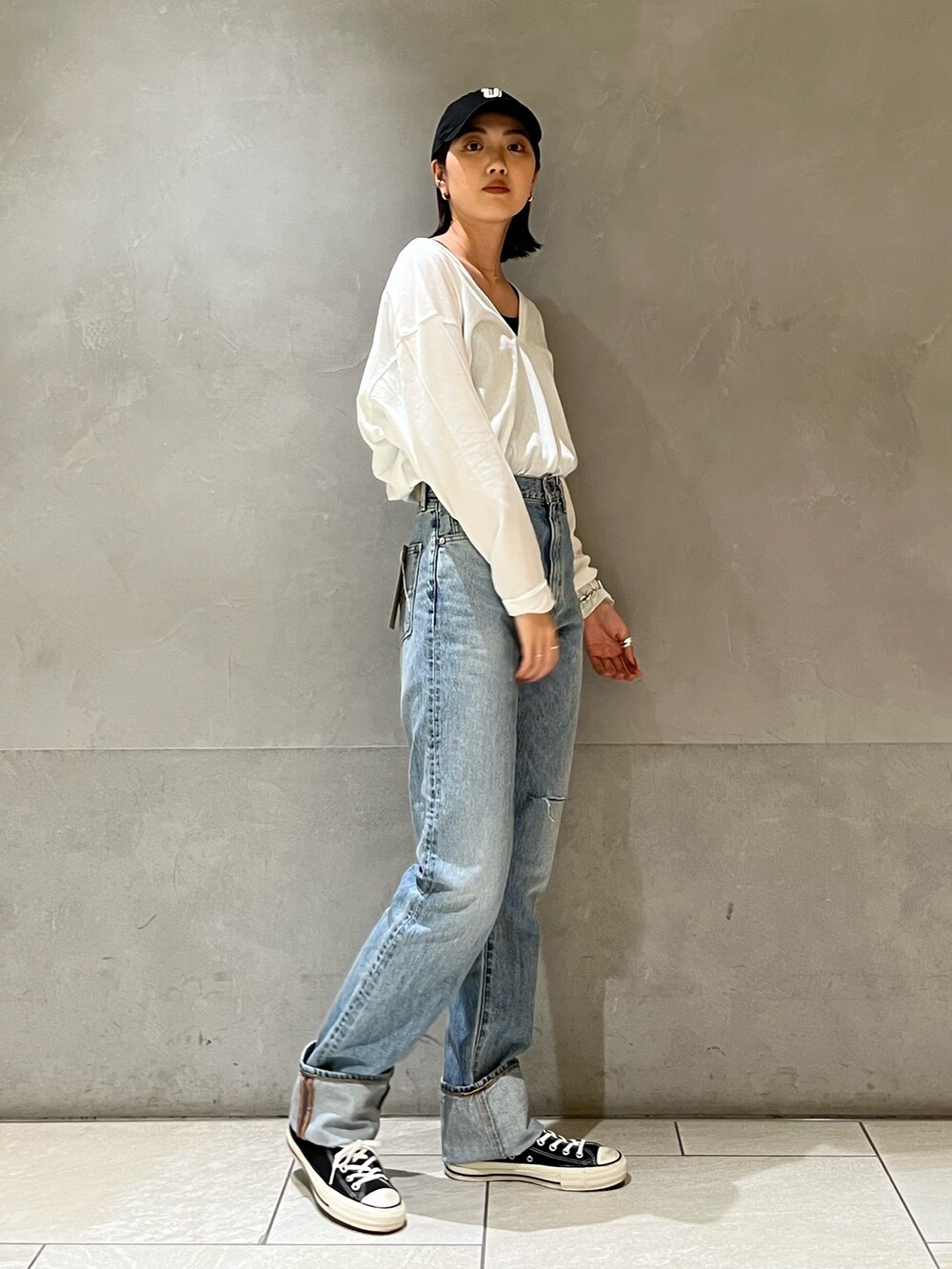 グリーン系のブルゾン、ホワイト系のTシャツ/カットソー、ブルー系のデニムパンツを着用したレディースの冬コーディネートの4枚目の写真