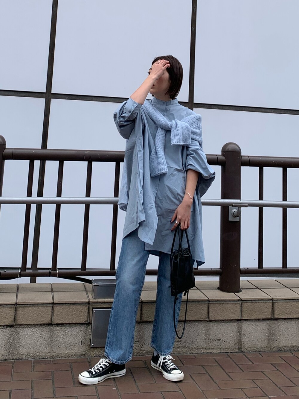 ブルー系のシャツ/ブラウス、ブルー系のニット/セーター、ブルー系のデニムパンツを着用したレディースの春コーディネートの4枚目の写真