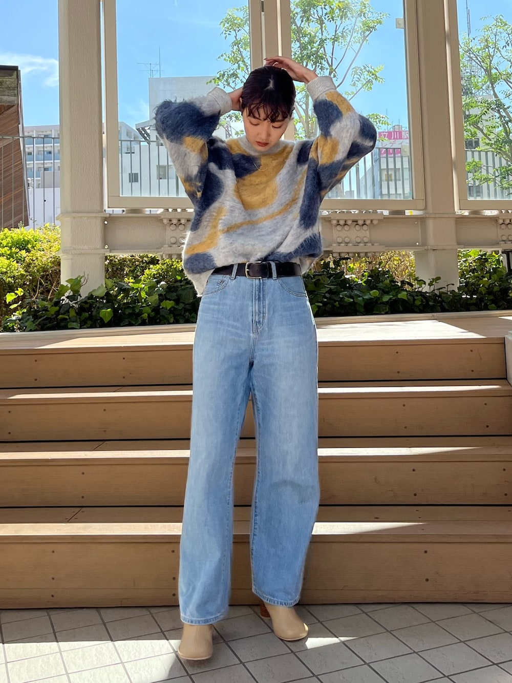 ブルー系のニット/セーター、ブルー系のデニムパンツ、ベージュ系のブーツを着用したレディースの秋コーディネートの3枚目の写真