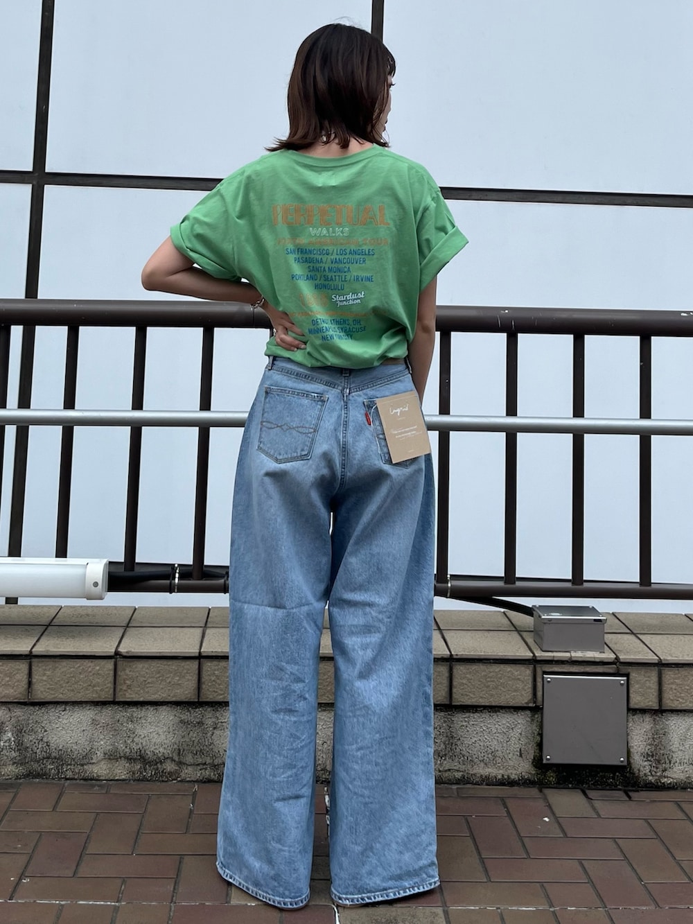 ブラック系のサンダル、グリーン系のTシャツ/カットソー、ブルー系のデニムパンツを着用したレディースの夏コーディネートの4枚目の写真