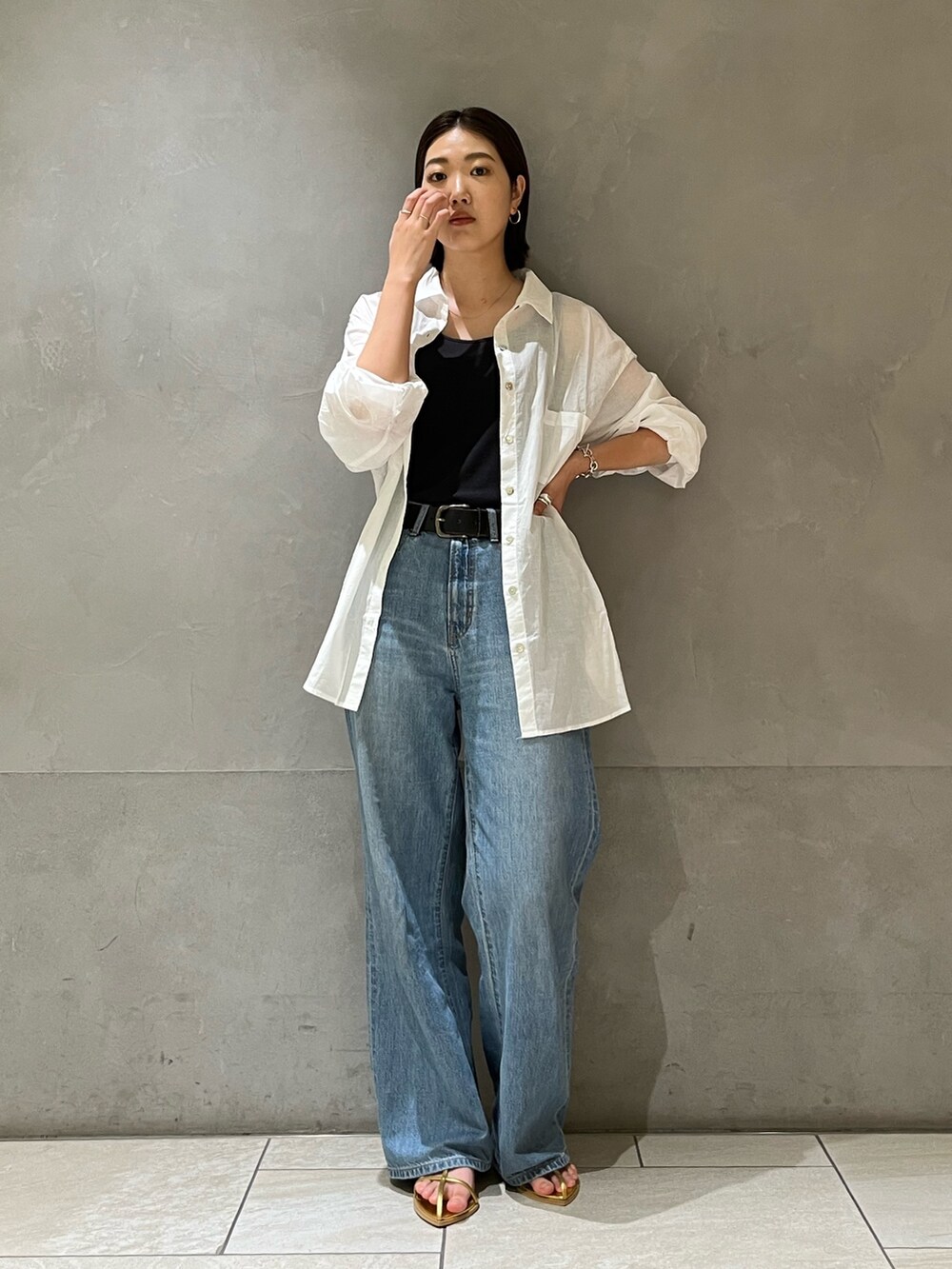 ホワイト系のシャツ/ブラウス、ブルー系のデニムパンツ、ゴールド系のサンダルを着用したレディースの夏コーディネートの2枚目の写真