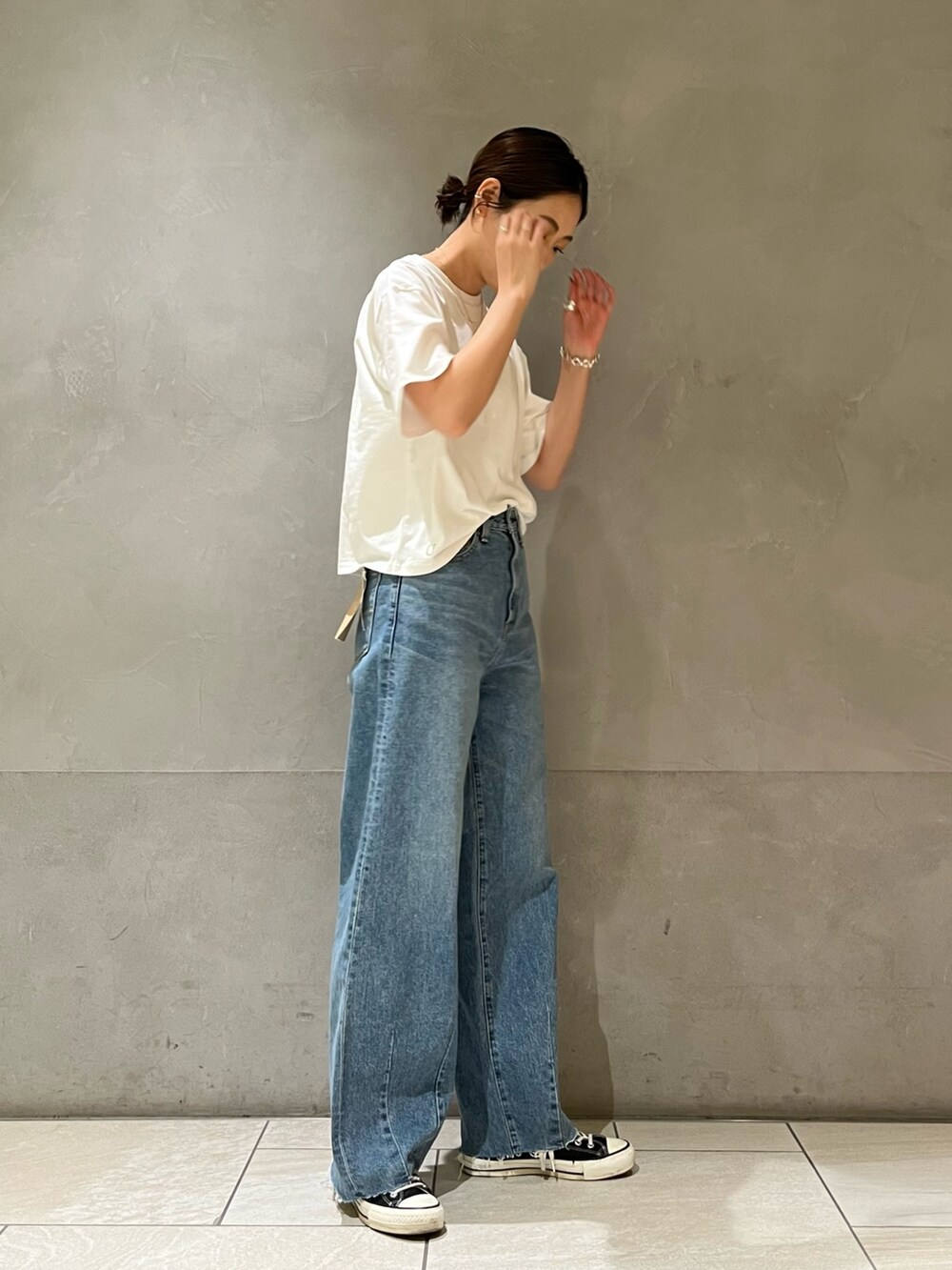 ブルー系のデニムパンツ、グリーン系のTシャツ/カットソーを着用したレディースの春コーディネートの2枚目の写真