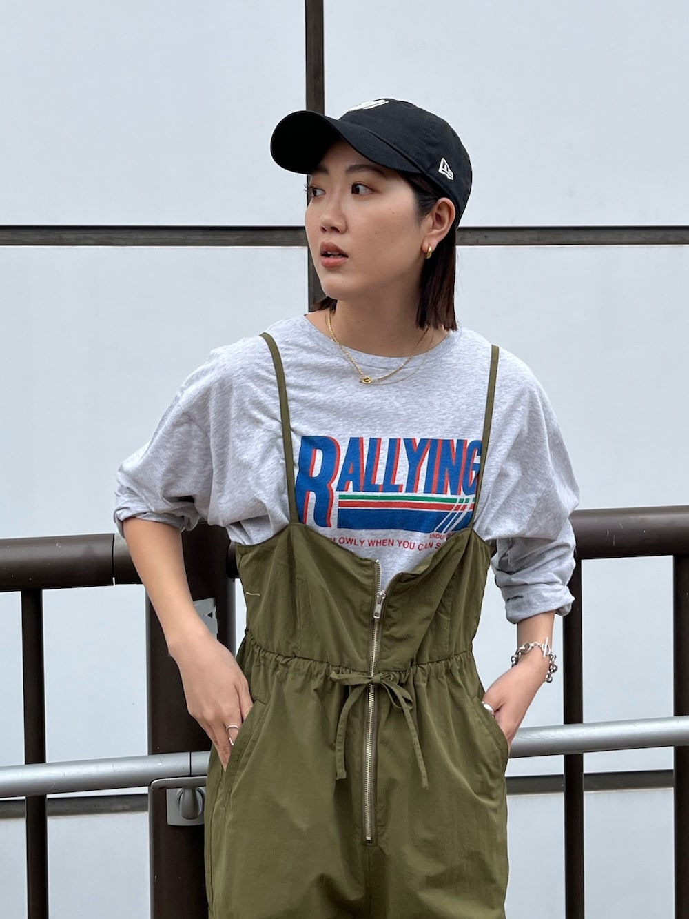 グリーン系のサロペット/オーバーオール、グレー系のTシャツ/カットソー、ベージュ系のステンカラーコートを着用したレディースの冬コーディネートの5枚目の写真