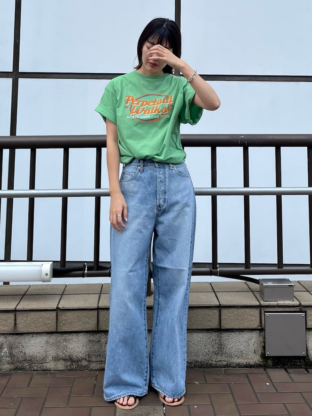 ブラック系のサンダル、グリーン系のTシャツ/カットソー、ブルー系のデニムパンツを着用したレディースの夏コーディネートの2枚目の写真