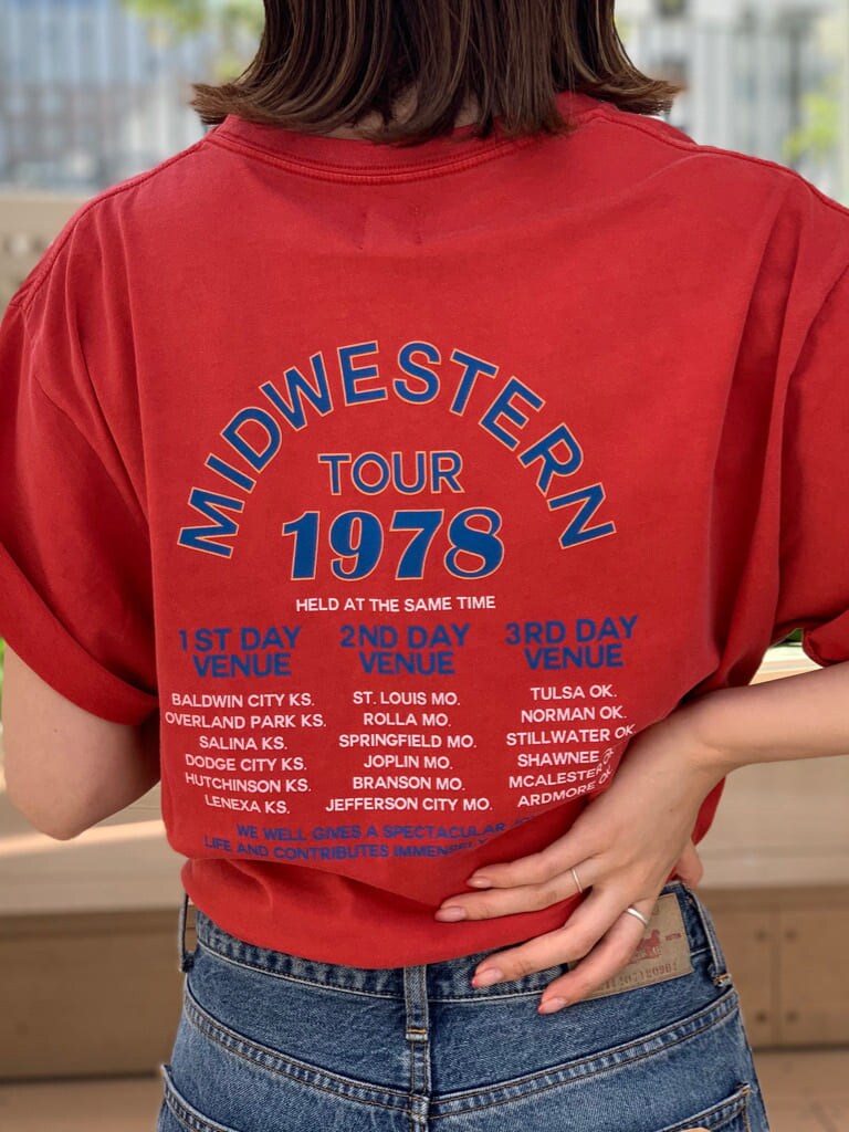 ブルー系のデニムパンツ、オレンジ系のTシャツ/カットソーを着用したレディースの春コーディネートの4枚目の写真