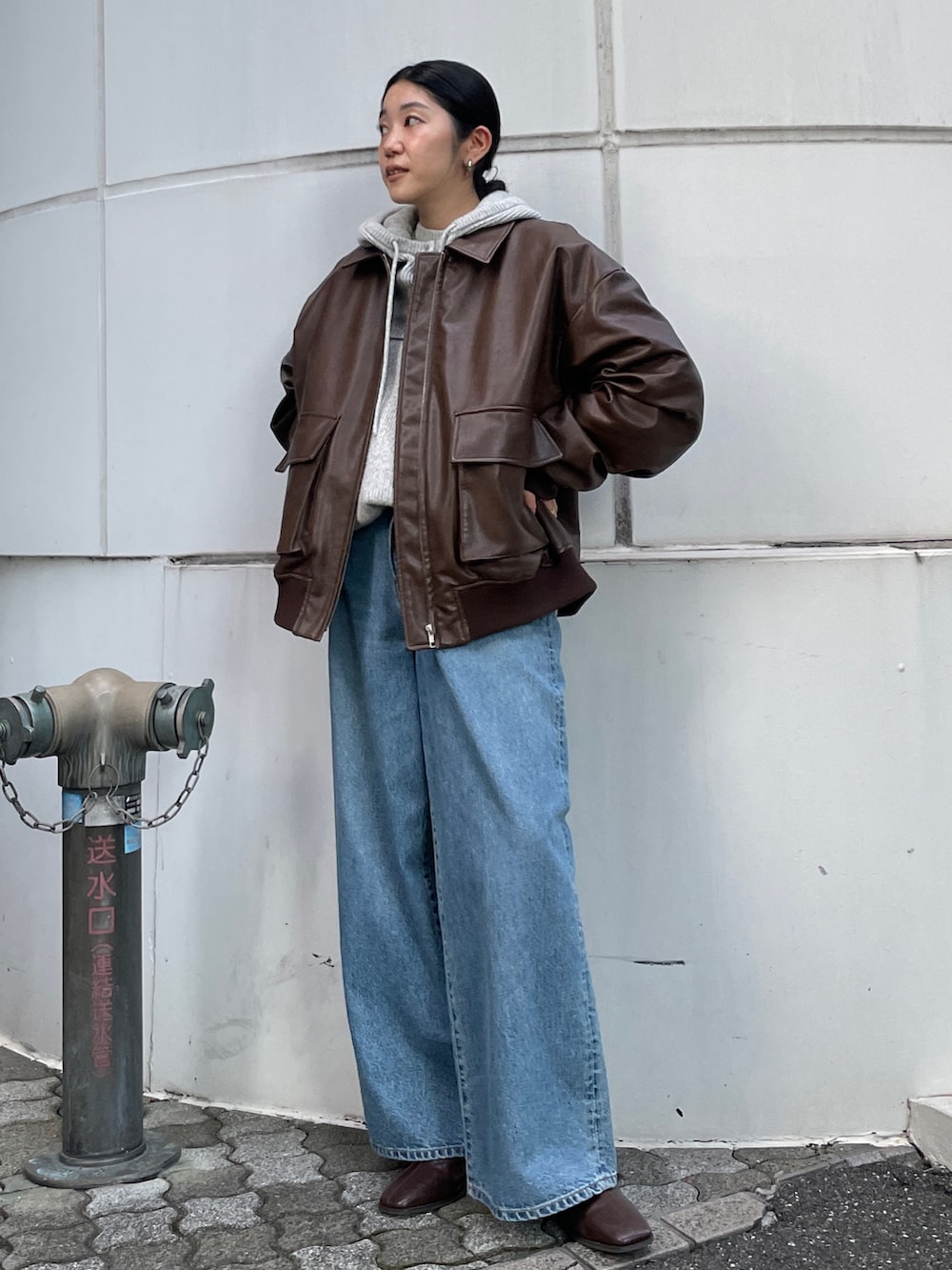 ブルー系のデニムパンツ、ブラウン系のブルゾン、ブラウン系のブーツを着用したレディースの秋コーディネートの2枚目の写真