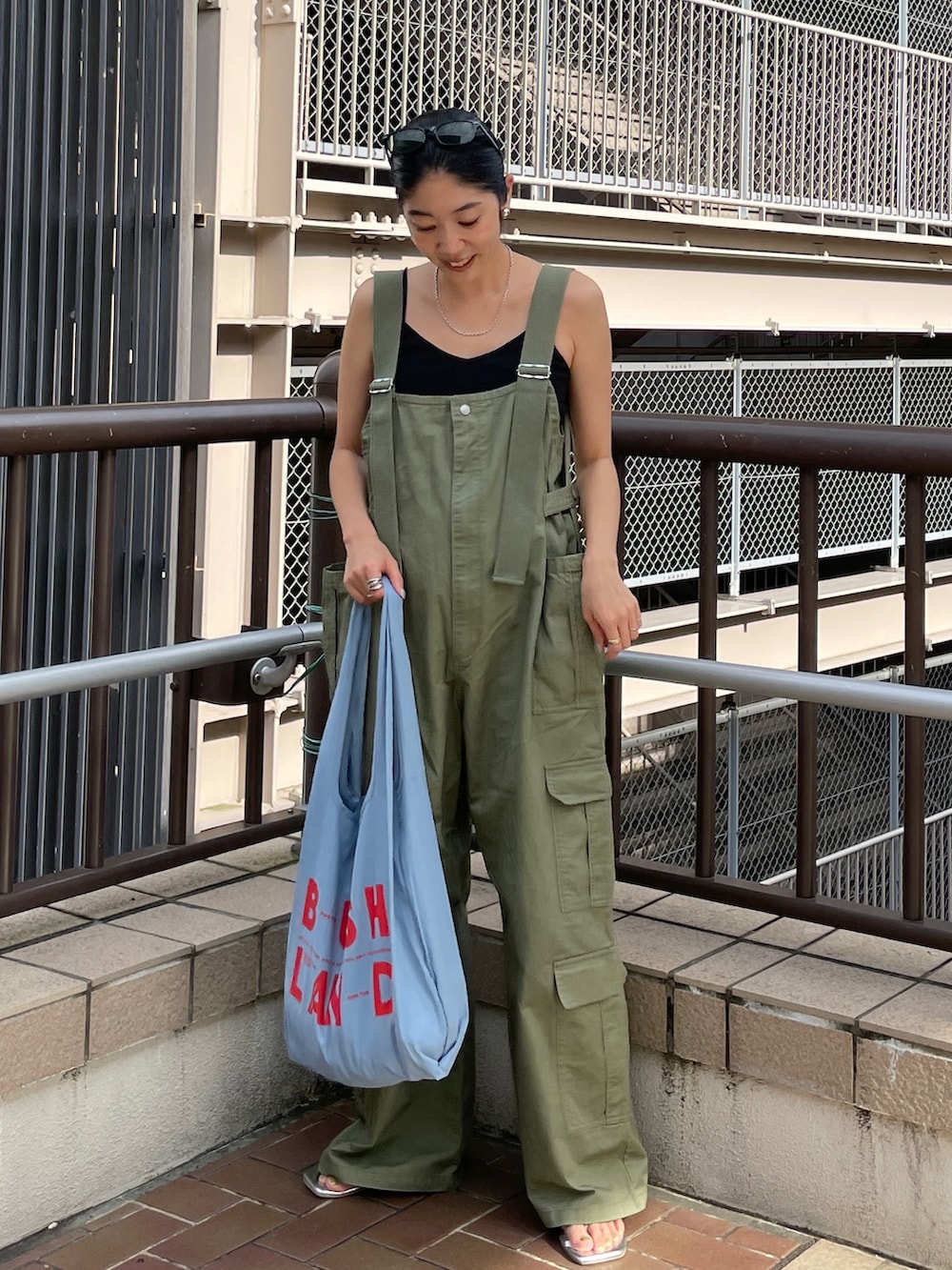 グリーン系のサロペット/オーバーオール、ブルー系のエコバッグ/サブバッグ、ブラック系のキャミソールを着用したレディースの夏コーディネートの5枚目の写真