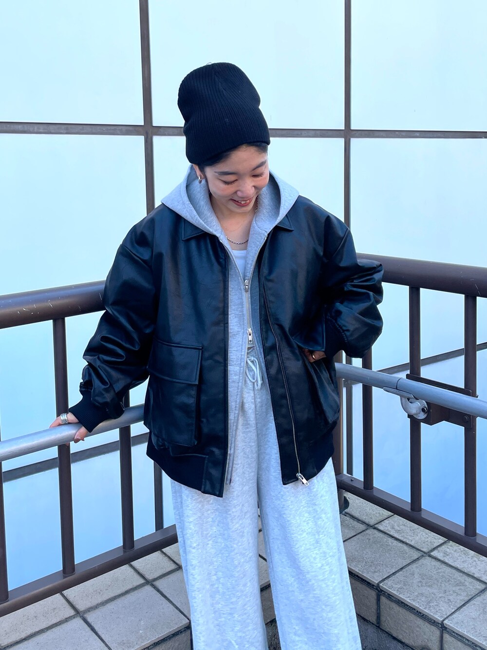 ブラック系のブルゾン、グレー系のパーカー、グレー系のスウェットパンツを着用したレディースの秋コーディネートの5枚目の写真