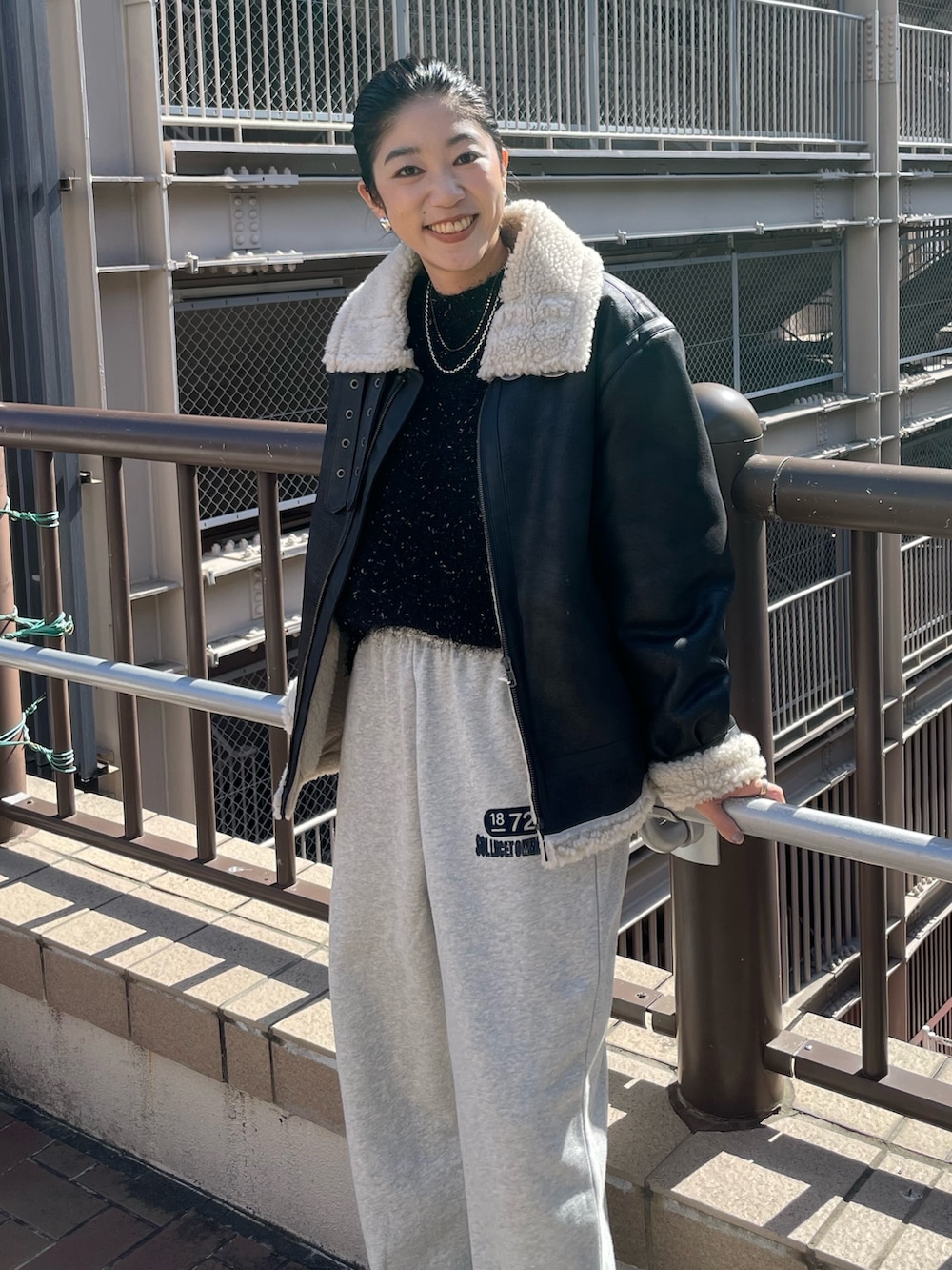 グレー系のスウェットパンツ、ブラック系のニット/セーター、ブラック系のムートンコートを着用したレディースの秋コーディネートの3枚目の写真