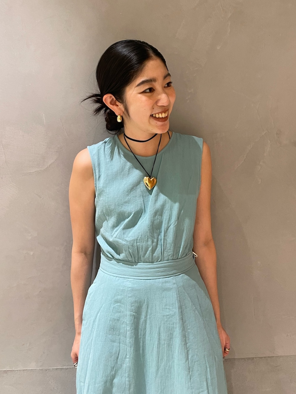 ブルー系のワンピース、ゴールド系のネックレスを着用したレディースの春コーディネートの3枚目の写真