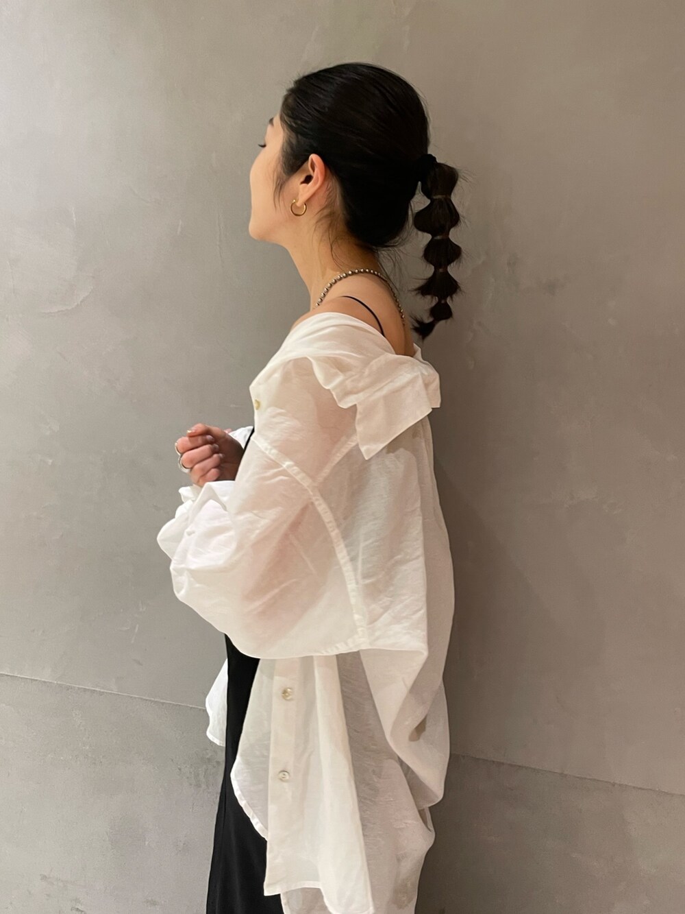 ブラック系のスカート、ホワイト系のシャツ/ブラウス、ブラック系のサンダルを着用したレディースの春コーディネートの4枚目の写真