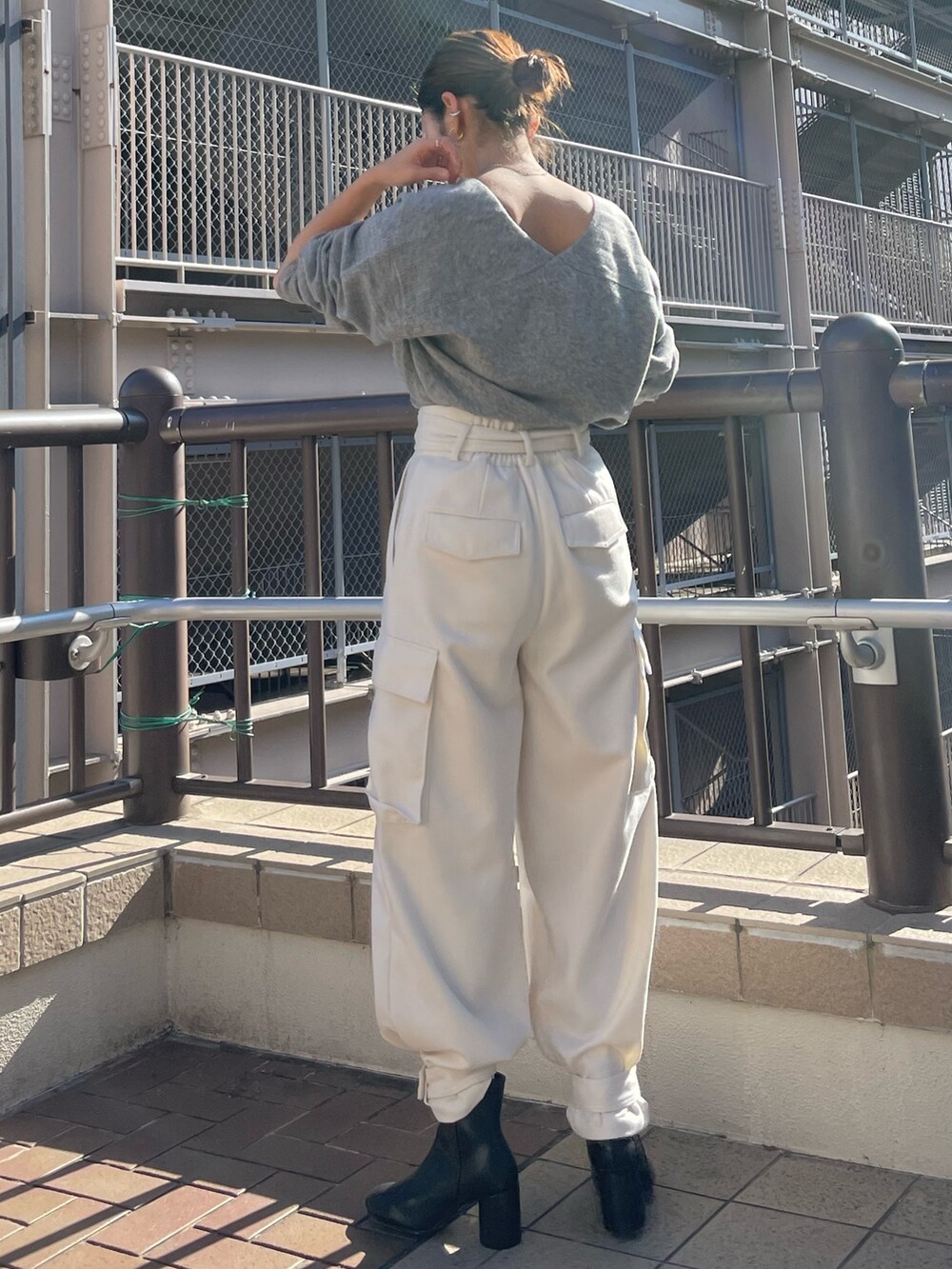 レッド系のニット/セーター、ホワイト系のカーゴパンツを着用したレディースの冬コーディネートの3枚目の写真