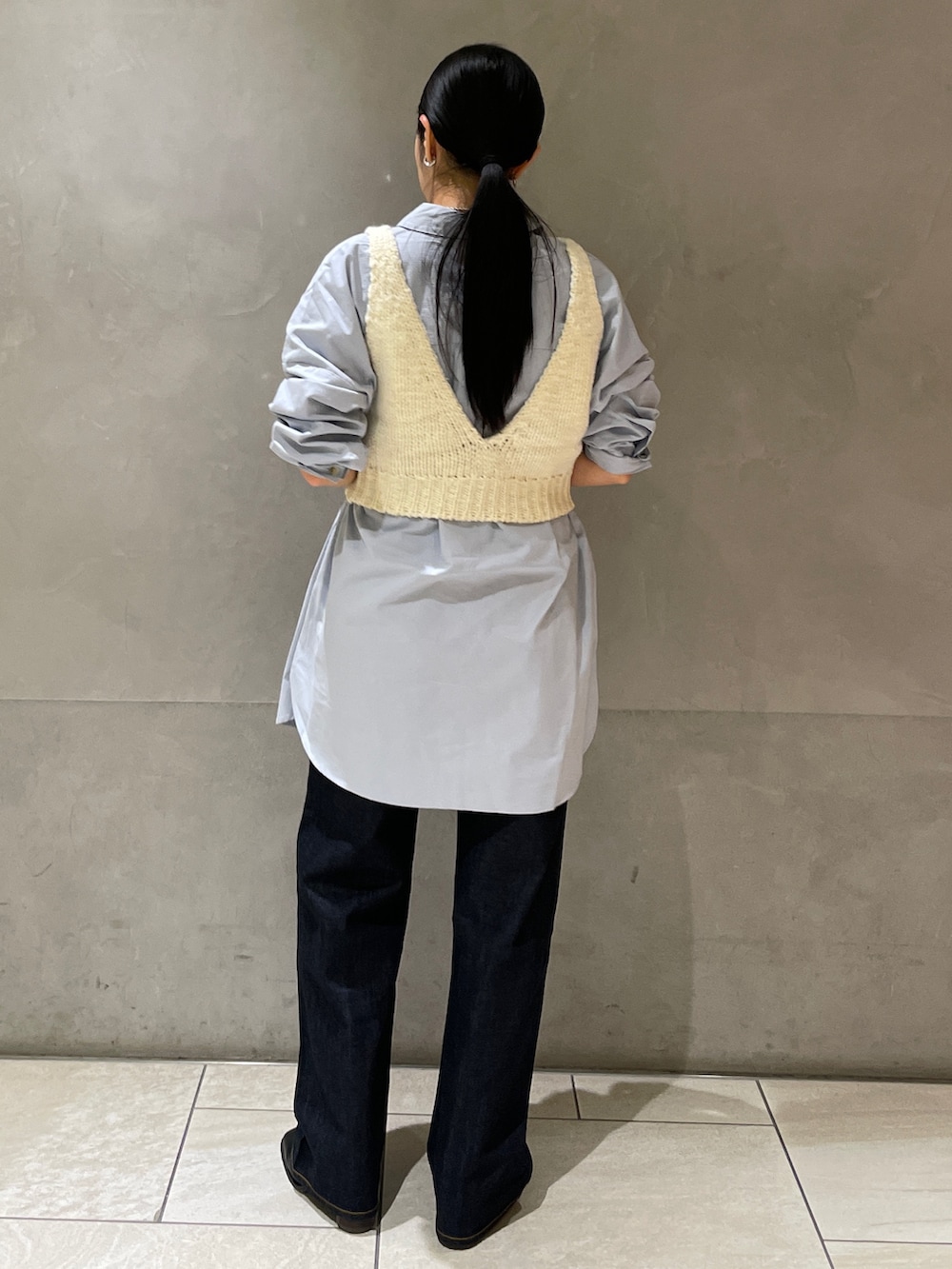 ブルー系のシャツ/ブラウス、ブルー系のデニムパンツ、ホワイト系のベストを着用したレディースの秋コーディネートの7枚目の写真