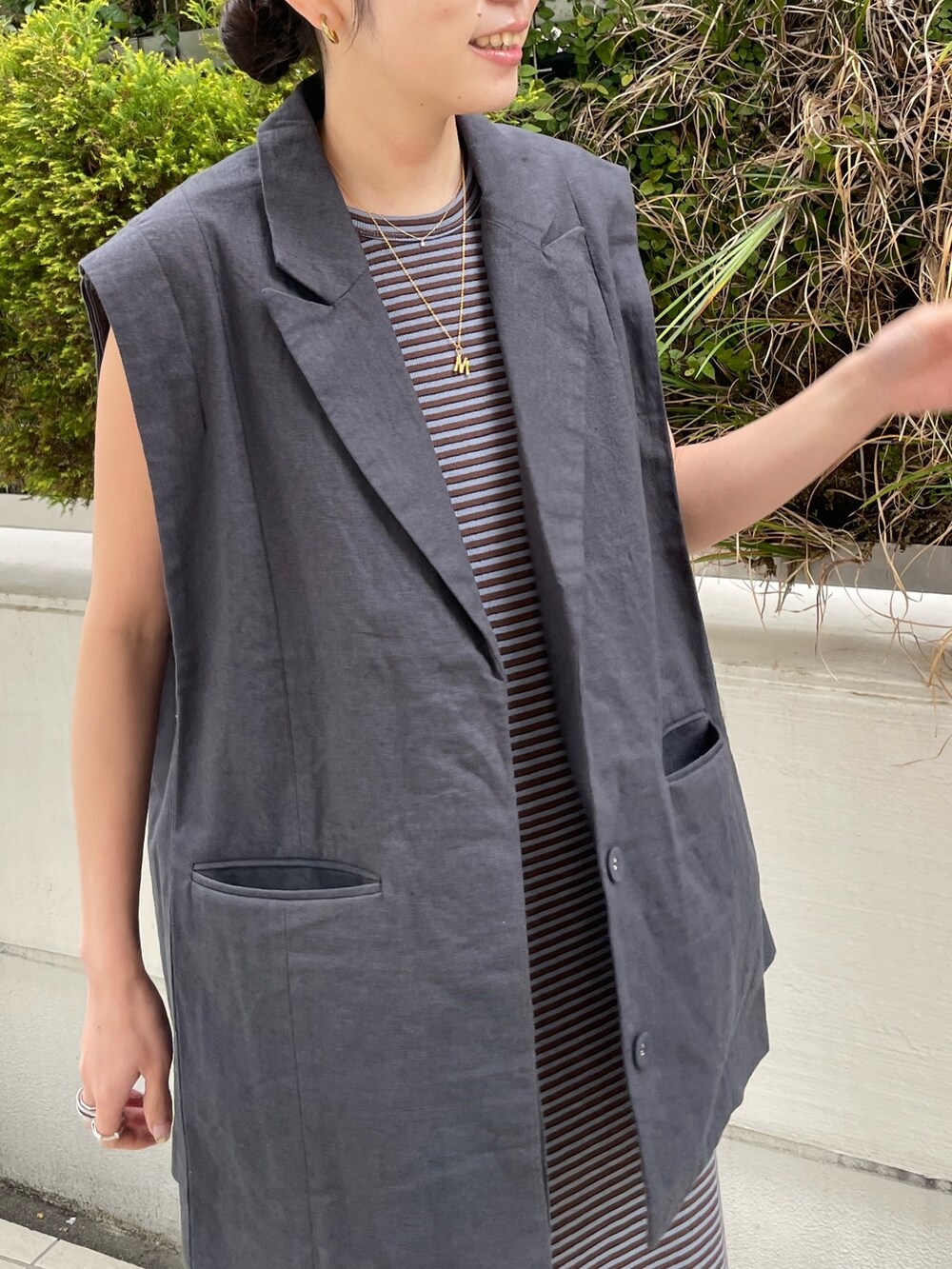 ブルー系のワンピース、ブラック系のサンダル、グレー系のテーラードジャケットを着用したレディースの春コーディネートの3枚目の写真