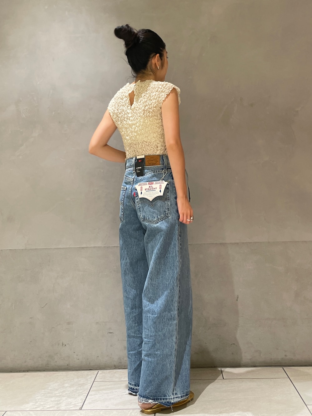 ホワイト系のシャツ/ブラウス、ブルー系のデニムパンツ、ゴールド系のローファーを着用したレディースの夏コーディネートの4枚目の写真