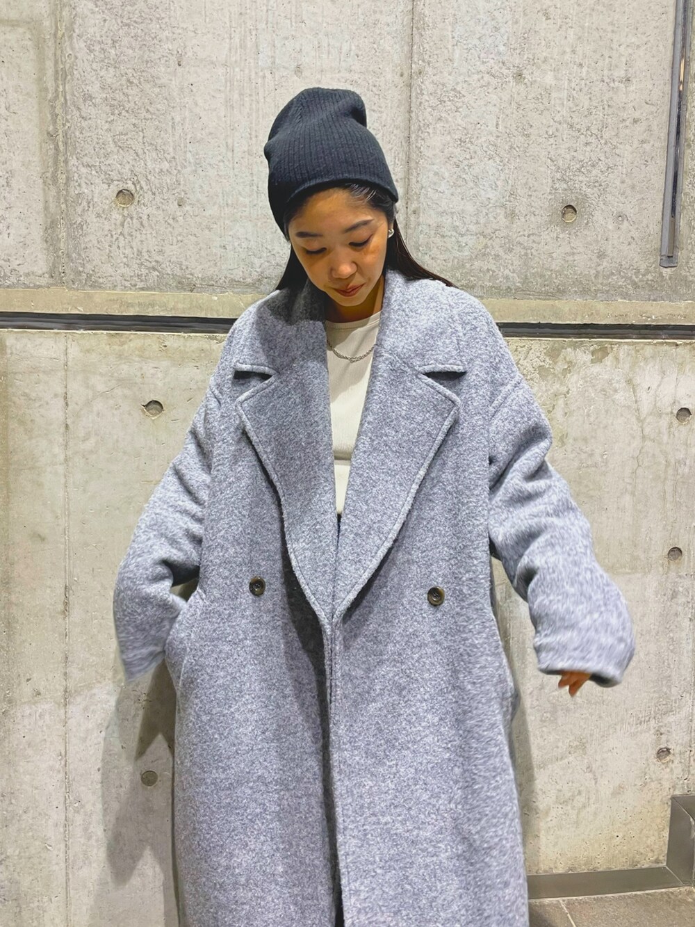 グレー系のチェスターコート、ブラック系のニットキャップ/ビーニーを着用したレディースの秋コーディネートの3枚目の写真