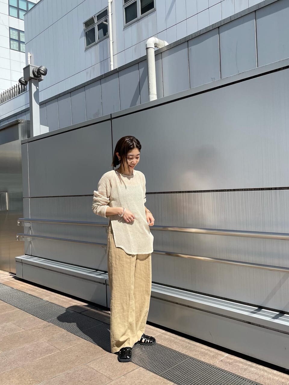 ベージュ系のその他パンツ、ブラック系のサンダル、ホワイト系のTシャツ/カットソーを着用したレディースの春コーディネートの3枚目の写真