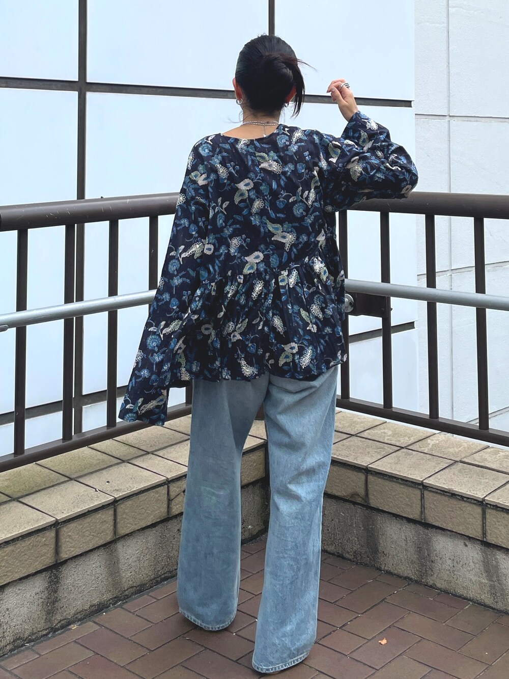 ブルー系のデニムパンツ、ゴールド系のローファー、ブルー系のシャツ/ブラウスを着用したレディースの夏コーディネートの3枚目の写真