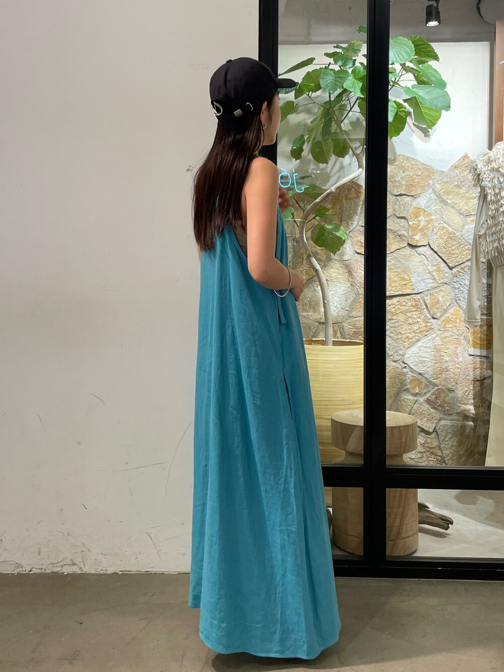 ブルー系のワンピース、グレー系のキャミソール、グレー系のキャップを着用したレディースの夏コーディネートの6枚目の写真