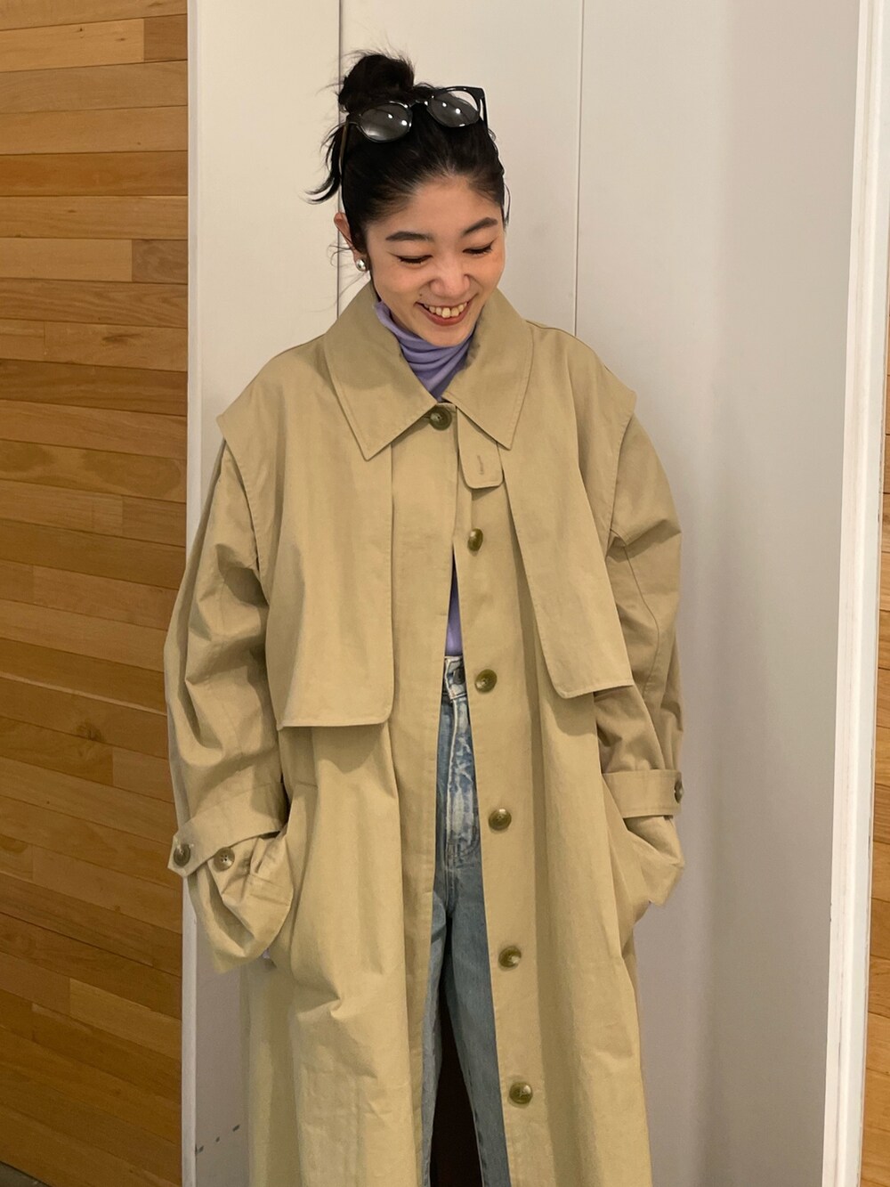 ブルー系のデニムパンツ、ベージュ系のその他アウター、パープル系のTシャツ/カットソーを着用したレディースの冬コーディネートの4枚目の写真