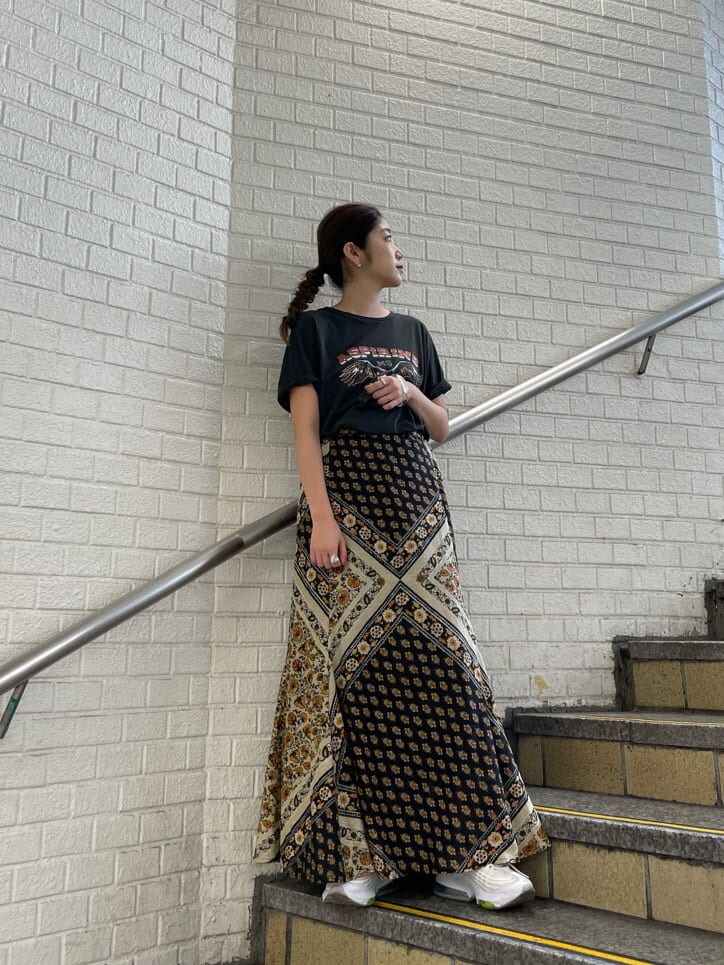 イエロー系のスカート、グレー系のTシャツ/カットソーを着用したレディースの夏コーディネートの2枚目の写真