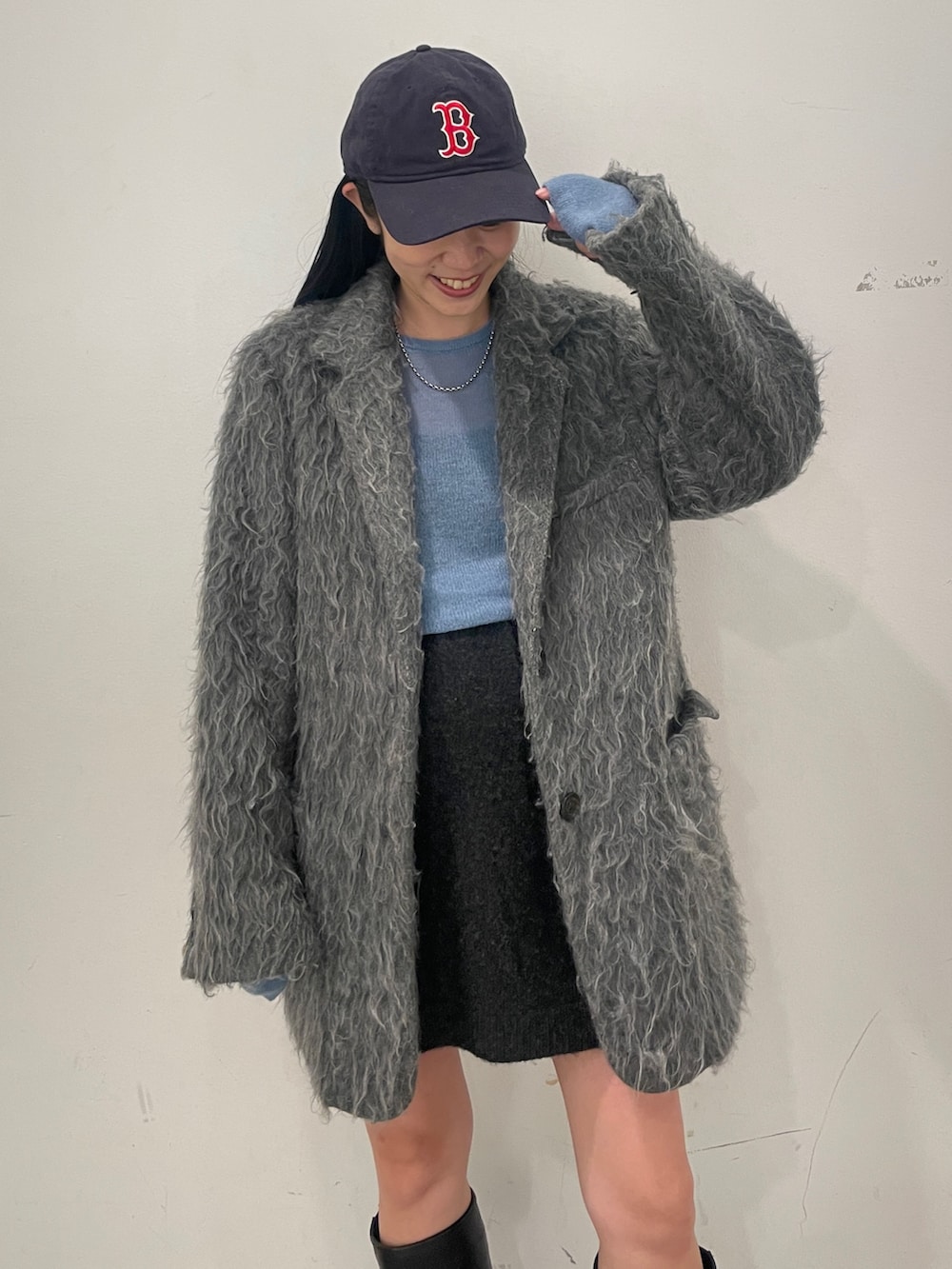 グレー系のテーラードジャケット、ブラック系のブーツ、グレー系のスカートを着用したレディースの秋コーディネートの2枚目の写真