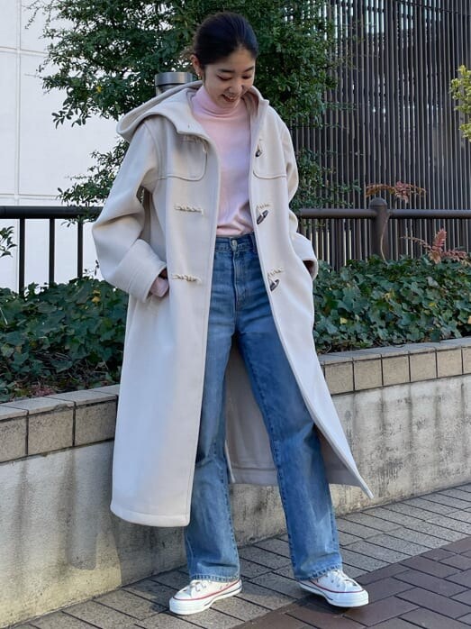 ブルー系のデニムパンツ、ホワイト系のダッフルコート、ピンク系のニット/セーターを着用したレディースの冬コーディネートの2枚目の写真