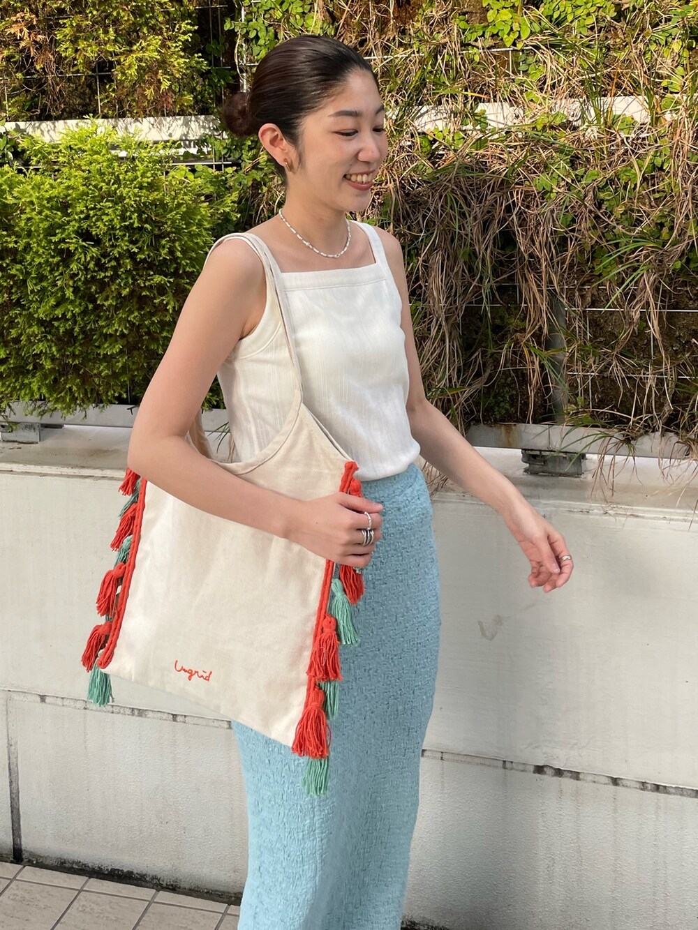 ブルー系のスカート、ホワイト系のタンクトップ、ブラック系のサンダルを着用したレディースの夏コーディネートの3枚目の写真