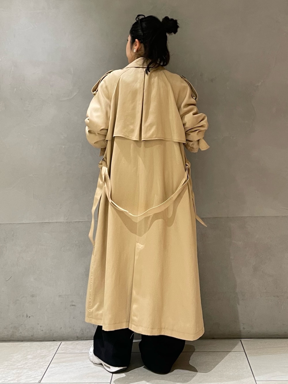 ベージュ系のトレンチコートを着用したレディースの春コーディネートの3枚目の写真