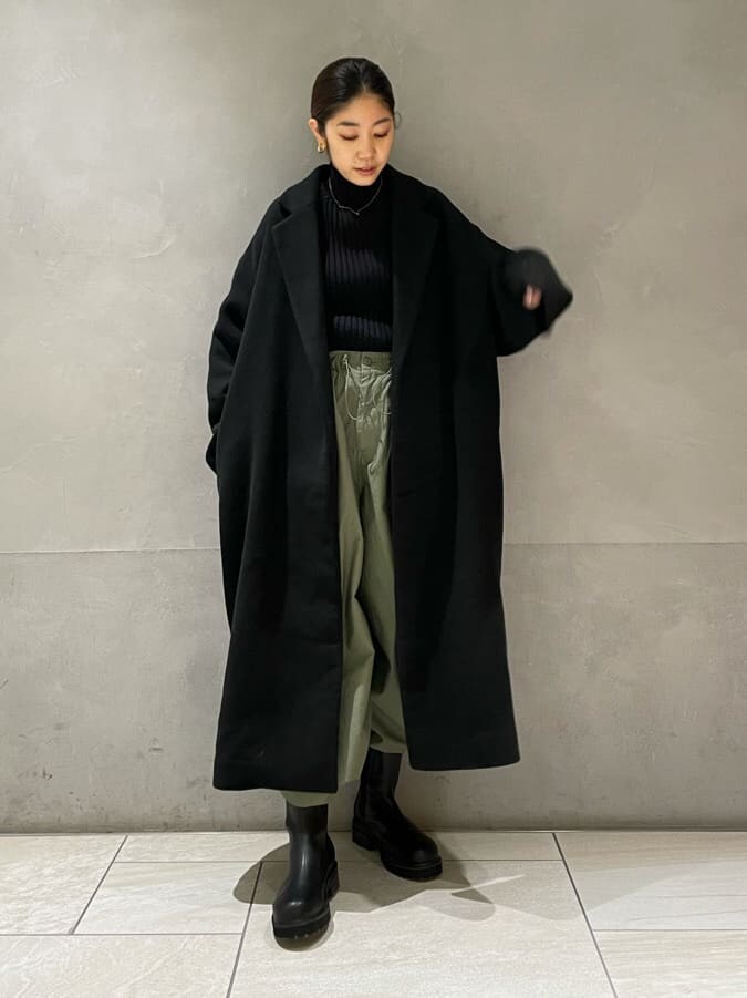 ブラック系のチェスターコート、ベージュ系のその他パンツ、ブラック系のニット/セーターを着用したレディースの秋コーディネートの5枚目の写真